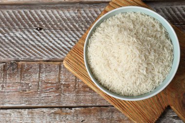 Tabakta çiğ basmati pilavı, ahşap masa, üst manzara. Metin için boşluk