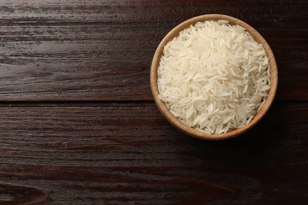 Tabakta çiğ basmati pilavı, ahşap masa, üst manzara. Metin için boşluk
