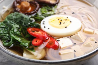 Yumurtalı, mantarlı, kasede tofu ve sebzeli nefis vejetaryen ramen, yakın plan. Erişte çorbası.
