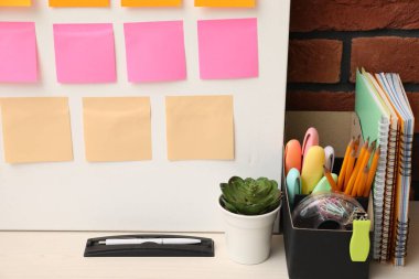 İş süreci planlaması ve optimizasyonu. Masada renkli kağıt notlar ve diğer kırtasiye malzemesi olan işyeri