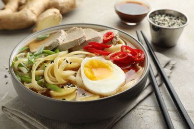 Kasede lezzetli ramen ve hafif desenli masada çubuklar, yakın plan. Erişte çorbası.