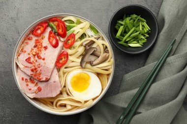 Gri desenli masada servis edilen tabakta nefis ramen. Erişte çorbası.