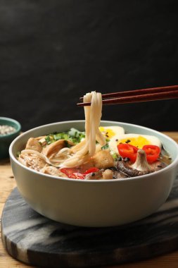 Yemek çubuklarıyla lezzetli ramen yemek, yakın plan. Erişte çorbası.