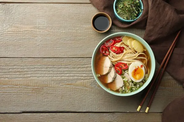 Kasede lezzetli ramen, soya sosu ve ahşap masada mikroyeşiller, yazı için yeri olan düz bir yer. Erişte çorbası.