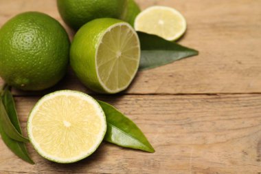 Tahta masada taze limon ve yapraklar, yakın plan. Metin için boşluk