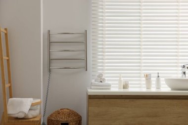 Isıtılmış havlu tırabzanı ve gösterişli bir banyo.