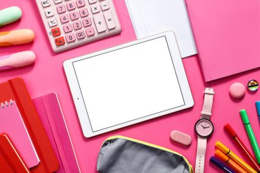 Modern tablet, hesap makinesi ve pembe arka planda kırtasiye malzemesi, düz konum. Metin için boşluk