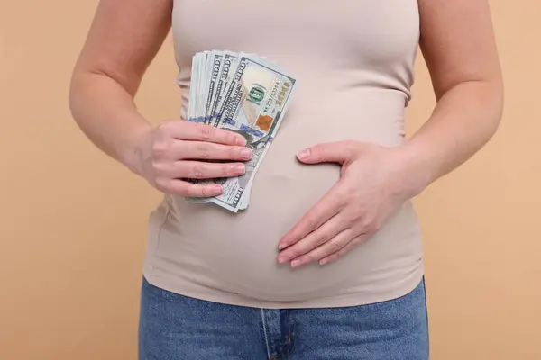 Суррогатная Мать Беременная Женщина Долларовыми Банкнотами Бежевом Фоне Крупным Планом — стоковое фото