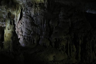 Karanlık mağaradaki birçok sarkık oluşumun resimli görüntüsü