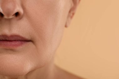 Bej arka planda normal tenli bir kadın, makro manzaralı. Metin için boşluk