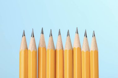 Turkuaz arka planda bir sürü keskin grafit kalem, metin için boşluk. Makro görünüm