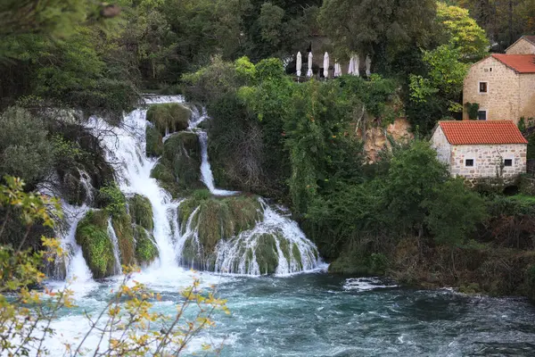 Güzel şelale manzarası ve açık hava binaları.