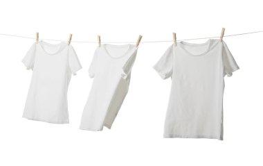 Çamaşır ipinde kuruyan birçok tişört beyaza izole edilmiş.