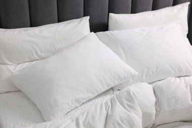 Yumuşak beyaz yastıklar ve yatakta yorgan