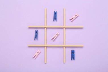 Leylak arkaplanındaki mandallarla yapılan tik tak parmak oyunu, üst görünüm