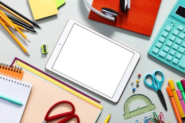 Gri zemin üzerine modern tablet ve kırtasiye malzemesi. Metin için boşluk