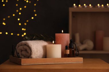 Bulanık ışıklara karşı ahşap masada farklı spa ürünleriyle güzel bir kompozisyon.