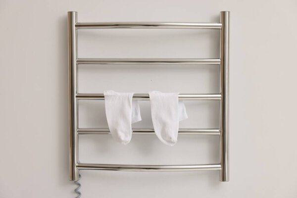 Heated towel rail with socks on white wall
