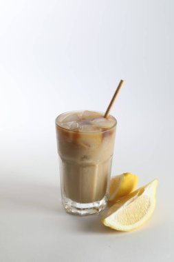 Sütlü buzlu kahve ve beyaz arka planda limon.