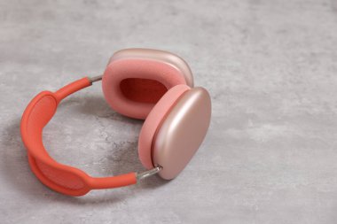 Açık gri masada pembe kulaklıklar, yakın plan. Metin için boşluk