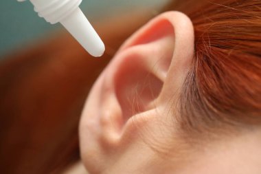 Tıbbi kulak damlası uygulayan kadın, makro görüş.