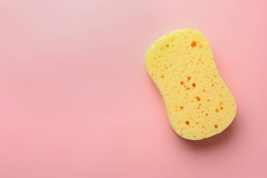 Pembe arka planda yeni sarı sünger, üst manzara. Metin için boşluk