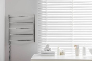 Banyodaki beyaz duvarda ısıtmalı havlu parmaklığı, mesaj için yer