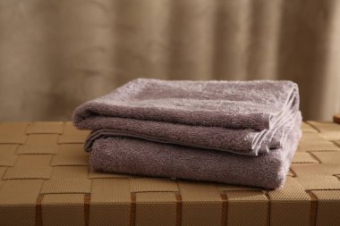 Hasır bankta yumuşak havlular, kapalı alanda, yakın plan.