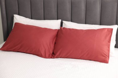 Yatağın üzerinde yumuşak yastıklar ve çizgili çarşaflar