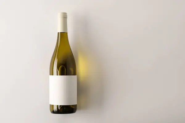 Bottle of tasty wine on white background, top view. Space for text
