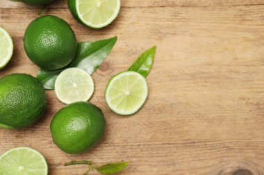 Tahta masanın üzerinde taze limon ve yapraklar, manzaranın üstünde. Metin için boşluk