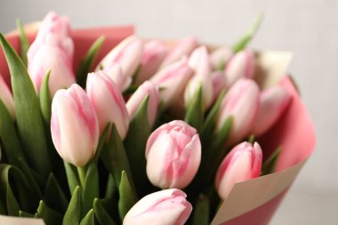 Açık arkaplanda pembe lalelerden oluşan güzel bir buket, yakın plan.