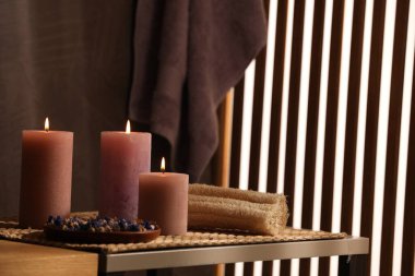 Spa kompozisyonu. İçerideki masada yanan mumlar ve kuru çiçekler.