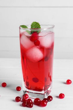 Lezzetli yaban mersini suyu. Bardakta buz, beyaz ahşap masada taze böğürtlen.