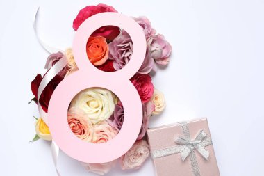 8 Mart tebrik kartı tasarımı, beyaz arka planda güller ve hediye kutusu, üst manzara. Uluslararası Kadınlar Gününüz kutlu olsun.