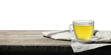 Beyaz arka planda, tahta masada fincanda yeşil çay tazeleniyor.