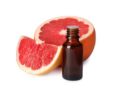 Bir şişe greyfurt yağı ve beyaz üzerine izole edilmiş taze meyve.