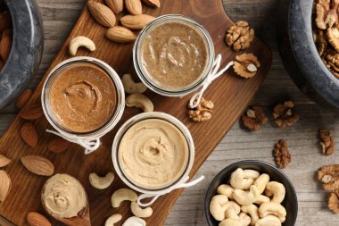 Farklı fıstıklardan fındık ezmesi yapıyorum. Ahşap masada yağlı bir bileşim var.