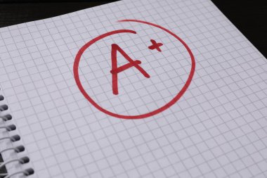 Okul derecesi. Not defteri kağıdında artı işareti olan kırmızı harf A, kapat
