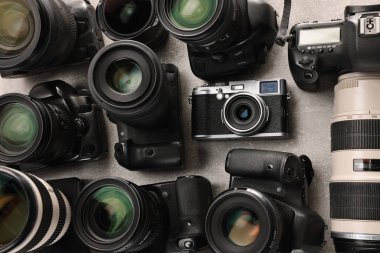 Gri desenli masa üzerinde modern kameralar, düz konum