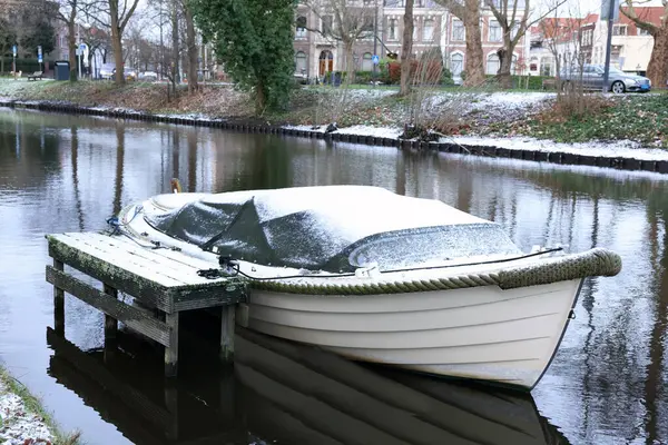 Water canal with moored boat on winter day