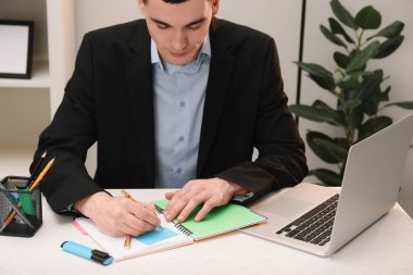 Ofisteki beyaz tahta masaya notlar alan bir adam.