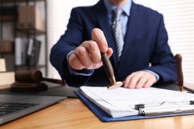 Ofisteki ahşap masada noter damgası belgesi, yakın plan.