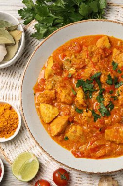 Lezzetli tavuk körisi ve malzemeler masanın üstünde.