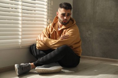 Üzgün adam pencerenin yanında oturuyor