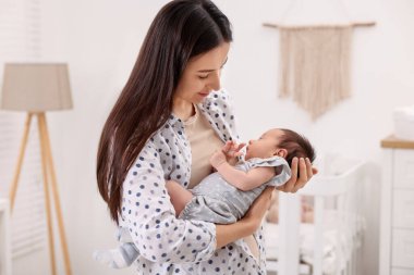 Anne, yeni doğmuş bebeğiyle evde uyuyor.