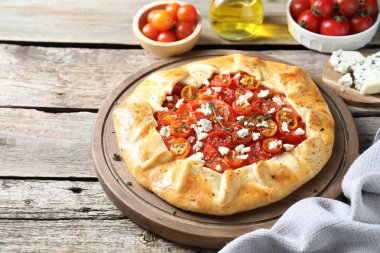 Ahşap masada domates, kekik ve peynirli lezzetli bir galet, yakın plan. Metin için boşluk