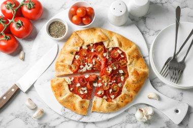 Beyaz mermer masa üzerinde domates, kekik ve peynir (Caprese galette) ile lezzetli galet düz bileşimi yatıyordu
