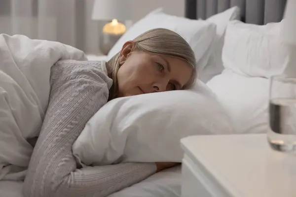 Menopause, sleep problems. Woman suffering from insomnia in bed indoors