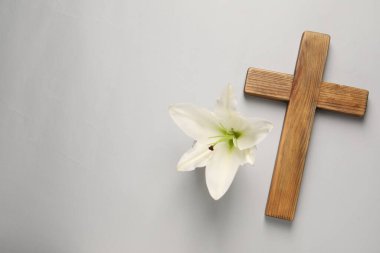 Ahşap haç ve gri arka planda zambak çiçeği, yazı için yeri olan üst manzara. Paskalya özellikleri